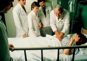 doctors around a patient beside